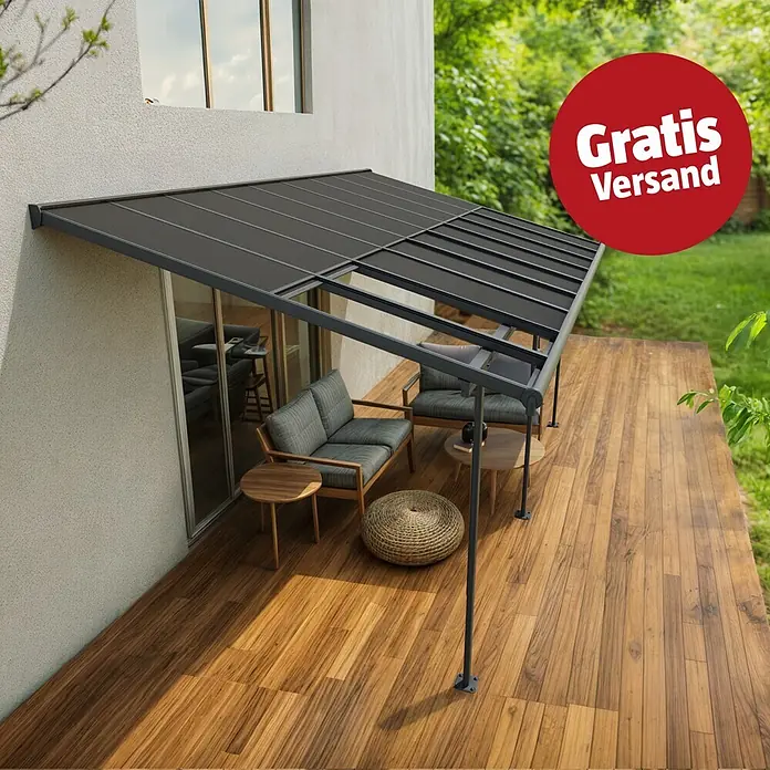 Palram – Canopia Terrassenüberdachung Sierra Cabrio - B x T: 560 x 300 cm, Anthrazitgrau, Polycarbonat, Grau - Dunkelgraue Terrassenüberdachung über einer Holzterrasse mit Sitzgelegenheiten, am Haus befestigt.