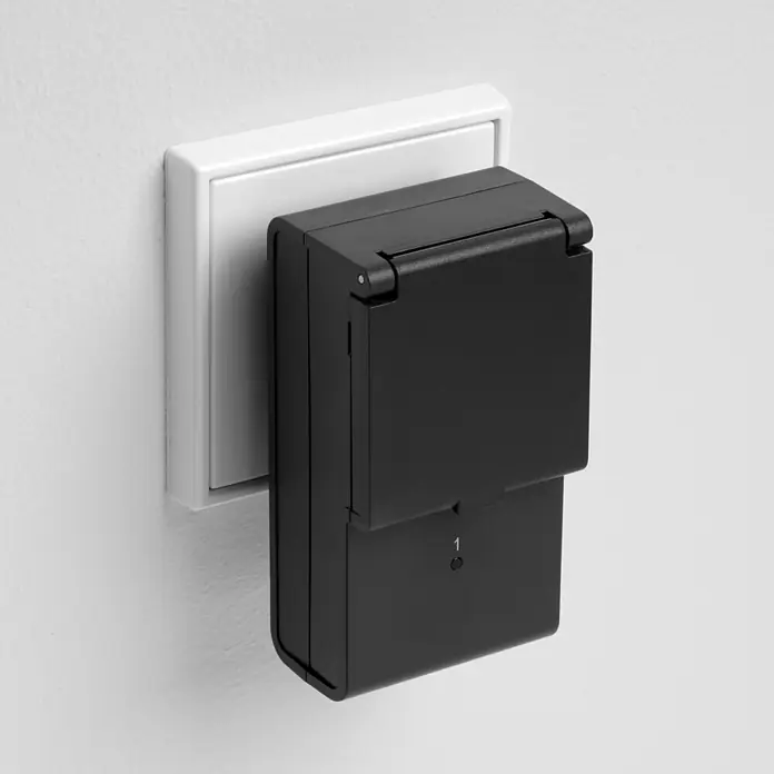 REV Funkschalter Set 2+1 außen 2 Stk. -  - Schwarzes, rechteckiges Gerät mit Klappdeckel, mit '1' beschriftet, in weißer Steckdose.