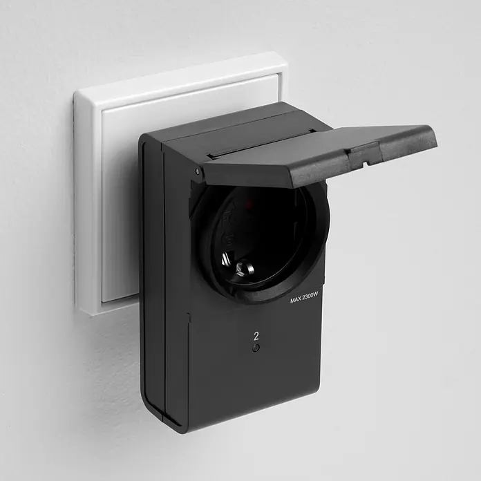 REV Funkschalter Set 2+1 außen 2 Stk. -  - Schwarzer Smart Plug mit offener Abdeckung, in Steckdose gesteckt, zeigt MAX 2300W.