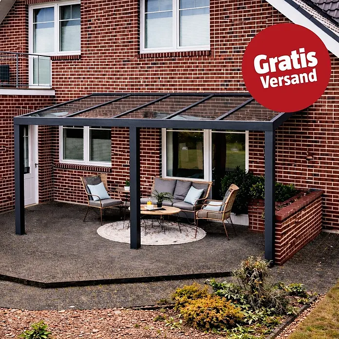 Gardendreams Terrassenüberdachung Elegance - B x T: 500 x 405,5 cm, Anthrazitgrau, Verbundsicherheitsglas (VSG), Klar - Dunkelgraue Terrassenüberdachung mit Glasdach, über einer möblierten Terrasse an einem Backsteinhaus.