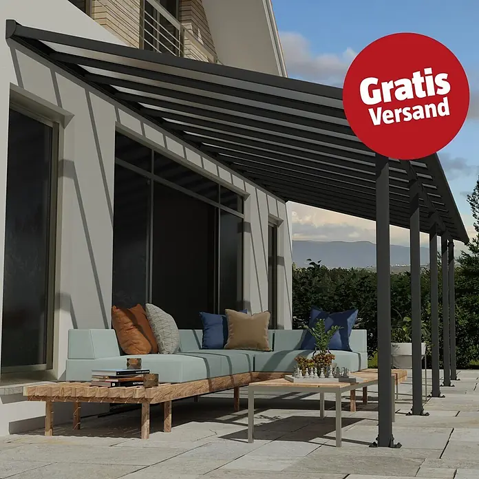 Palram – Canopia Terrassenüberdachung Olympia - B x T: 850 x 300 cm, Anthrazitgrau, Polycarbonat, Transparent - Dunkelgraue Pergola mit gerippten Dachpaneelen über einer Terrasse mit Gartenmöbeln, an einem Haus befestigt.
