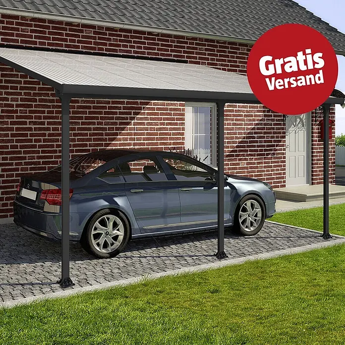 Solid Elements Terrassenüberdachung Martina - B x T: 425 x 400 cm, Anthrazitgrau, Polycarbonat, Transparent - Dunkelgrauer Carport mit hellgrauem Wellendach, an einem Backsteinhaus angebracht, schützt ein blaues Auto auf einer gepflasterten Einfahrt.