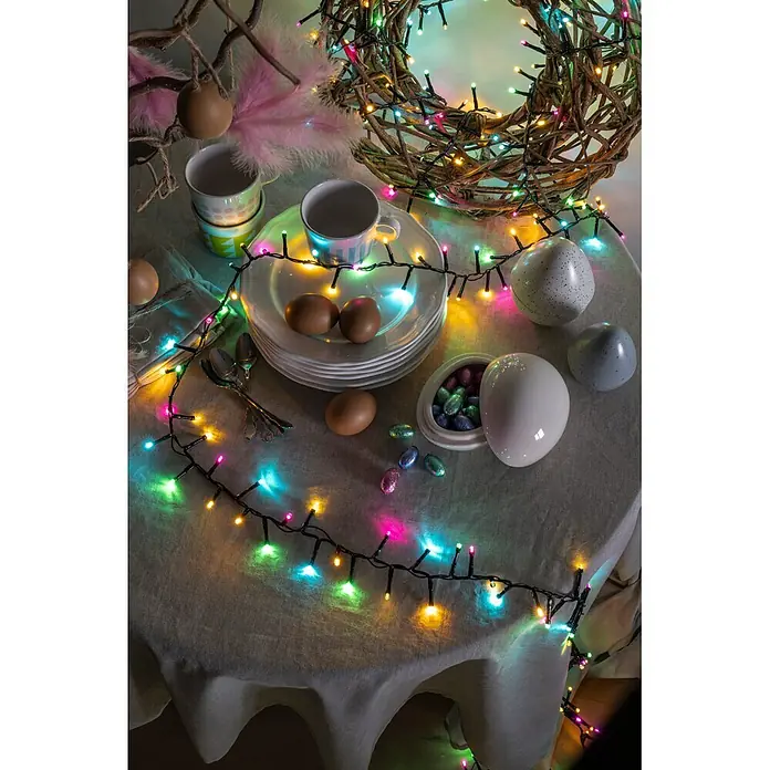 Konstsmide LED-Clusterlichterkette Pastell - Außen, Länge: 8,78 cm, 400 Stk., Netzbetrieben - Bunte LED-Lichterkette dekoriert einen Ostertisch mit Eiern und Tassen.