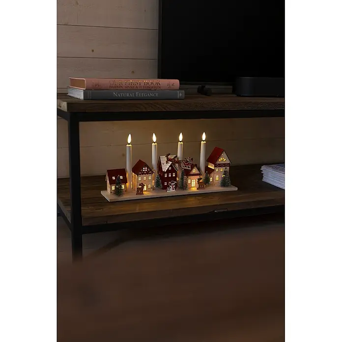 Konstsmide LED-Holzsilhouette Miniaturhäuser - 47 x 11 x 20,5 cm, Braun, Batteriebetrieben, Warmweiß - Beleuchtetes Weihnachtsdorf mit vier LED-Kerzen, Häusern, Weihnachtsmann und Bäumen auf einer Holz-TV-Konsole.