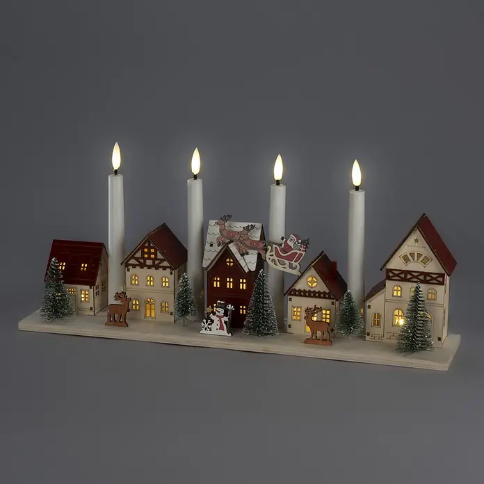 Konstsmide LED-Holzsilhouette Miniaturhäuser - 47 x 11 x 20,5 cm, Braun, Batteriebetrieben, Warmweiß - Beleuchtetes Weihnachtsdorf aus Holz mit vier LED-Kerzen, Häusern, Bäumen und Figuren auf hellem Holzsockel.