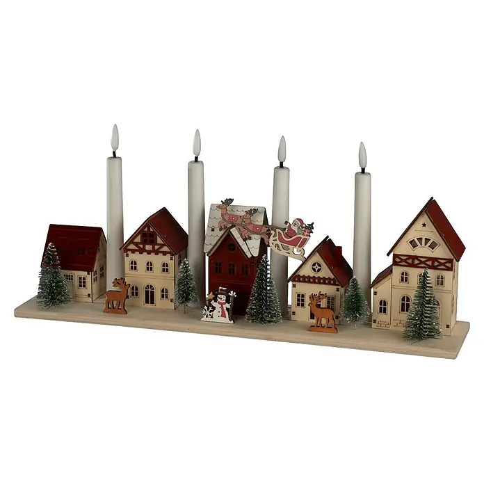 Konstsmide LED-Holzsilhouette Miniaturhäuser - 47 x 11 x 20,5 cm, Braun, Batteriebetrieben, Warmweiß - Adventskalender-Weihnachtsdorf aus Holz mit vier weißen Kerzen, Häusern, Bäumen und festlichen Figuren auf hellem Sockel.