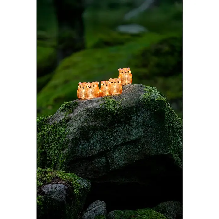 Konstsmide LED-Dekofigur - Außen, Lichtfarbe: Warmweiß, Anzahl Leuchtmittel: 40 Stk., Netzbetrieben - Fünf leuchtende, bernsteinfarbene Eulenfiguren strahlen warm auf einem moosbewachsenen Felsen.