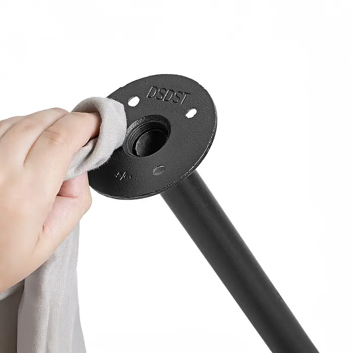 Walteco Rusticline Anti-Rutsch-Pad RT-61, Ø83mm,4STK - Durchmesser: 83 mm, Schwarz, Kleben, 4 Stk. - Eine Hand wischt einen schwarzen Industrierohrflansch und ein Rohr mit einem hellen Tuch ab.