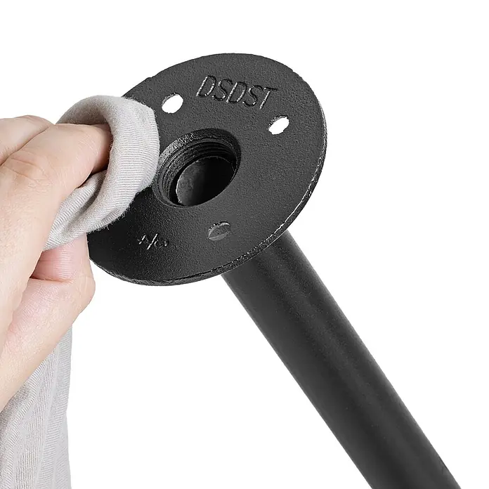 Walteco Rusticline Anti-Rutsch-Pad RT-61, Ø83mm,4STK - Durchmesser: 83 mm, Schwarz, Kleben, 4 Stk. - Eine Hand reinigt ein schwarzes Industrie-Rohrverbindungsstück mit einem Tuch, das Flansch und angeschlossenes Rohr zeigt.