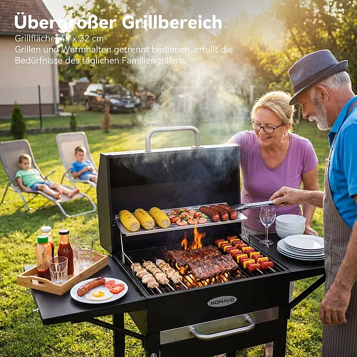 HOMAVO Holzkohlegrill - schwarz - Schwarzer HOMAVO Grill in Benutzung, beladen mit Grillgut, bedient von Erwachsenen bei einem Familien-Grillfest im Garten.