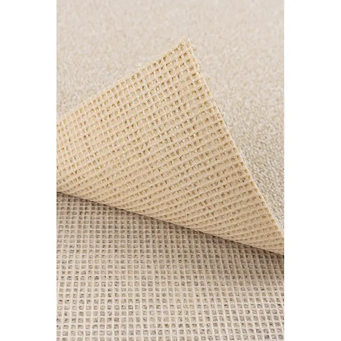 Bricoflor Teppichboden Meterware 4x4m, Schlinge meliert, hell-beige weiß - Schlinge, 100 % Polyamid (PA), hell-beige weiß - Beige, waffelgemusterte rutschfeste Teppichunterlage, teilweise angehoben, um die Netzstruktur zu zeigen.
