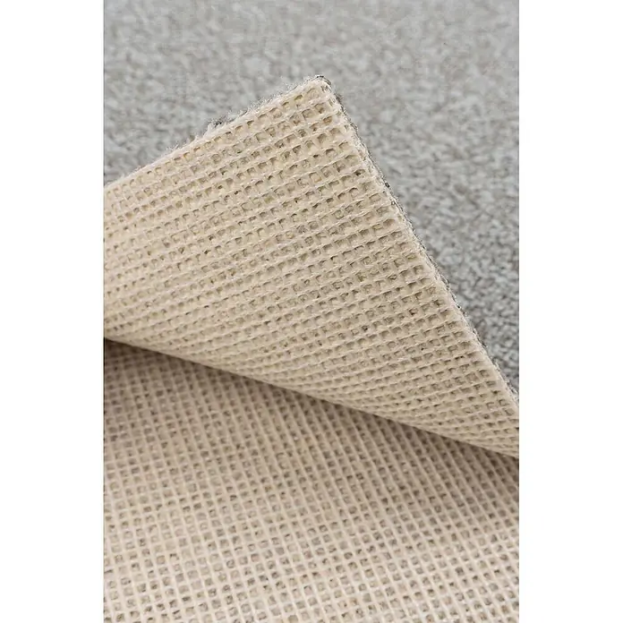 Bricoflor Teppichboden Meterware 4,5x4m, Schlinge meliert, hell-grau beige - Schlinge, 100 % Polyamid (PA), hell-grau beige - Beige Wabenstruktur-Antirutschunterlage eines grauen Teppichs, teilweise angehoben.