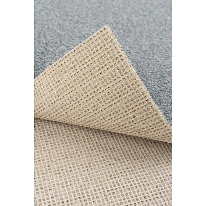 Bricoflor Teppichboden Meterware 4,5x5m, Schlinge meliert, hell-grau weiß - Schlinge, 100 % Polyamid (PA), hell-grau weiß - Beige Anti-Rutsch-Teppichunterlage mit Gitterstruktur, teilweise von grauem Teppich angehoben.