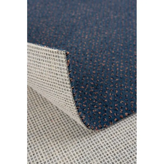 Bricoflor Teppichboden Meterware 8,5x4m, Velours gemustert, dunkel-blau grau - Velours, 100 % Polyamid (PA), dunkel-blau grau - Blauer Teppich mit braunen Sprenkeln, hochgeklappt zeigt er seine helle, netzartige Anti-Rutsch-Unterseite.
