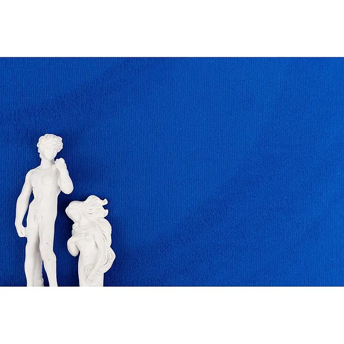 Bricoflor Teppichboden Meterware 5x4m, Velours uni, blau - Velours, 100 % Polyamid (PA), blau - Zwei weiße Dekorationsstatuen, eine männliche Figur ähnlich David und eine weibliche Figur, auf blauem Hintergrund.