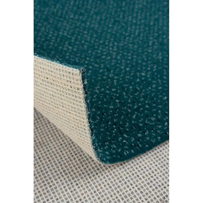 Bricoflor Teppichboden Meterware 8x4m, Velours gemustert, türkis grün - Velours, 100 % Polyamid (PA), türkis grün - Türkiser Teppich, teilweise angehoben, zeigt seine strukturierte Oberseite und weiße rutschfeste Gitterunterseite.