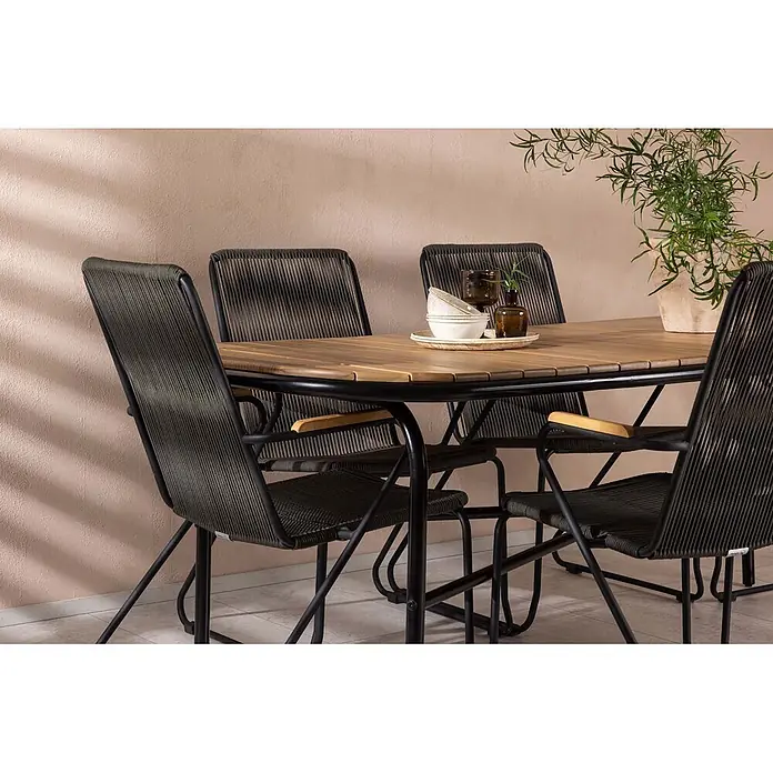 Ebuy24 Gartentisch-Set Holmbeck - Gesamtumfang: 7 -tlg., L x B x H: 90 x 200 x 75 cm, Ø x H: 90 x 75 cm, Stahl Akazie, Stapelbar - Eine Outdoor-Essgruppe mit einem Holztisch mit Lamellen und vier dunkel geflochtenen Stühlen mit schwarzen Gestellen und Holzarmlehnen.