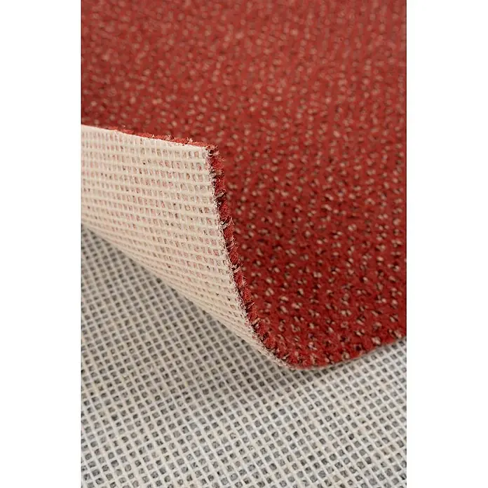 Bricoflor Teppichboden Meterware 3x4m, Velours gemustert, orange terra - Velours, 100 % Polyamid (PA), orange terra - Strukturierter roter Teppich mit gewebter Unterseite, teilweise angehoben, um eine rutschfeste Gitterunterlage darunter zu zeigen.
