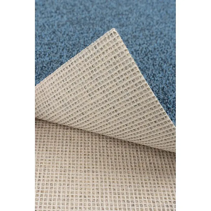 Bricoflor Teppichboden Meterware Schlinge meliert, blau grau, 550 x 400 cm - Breite: 400 cm, Schlinge, 100 % Polyamid (PA), blau grau - Beigefarbene, gittergemusterte Antirutsch-Teppichunterlage, teilweise von blauem Teppich angehoben.