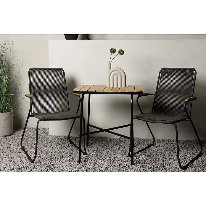 Ebuy24 Gartentisch-Set Holmbeck - Gesamtumfang: 3 -tlg., L x B x H: 88 x 70 x 74 cm, Ø x H: 88 x 74 cm, Stahl Akazie, Stapelbar - Zwei Outdoor-Stühle mit dunkelgrauen geflochtenen Schnüren und ein kleiner Holztisch auf einer Kiesterrasse.