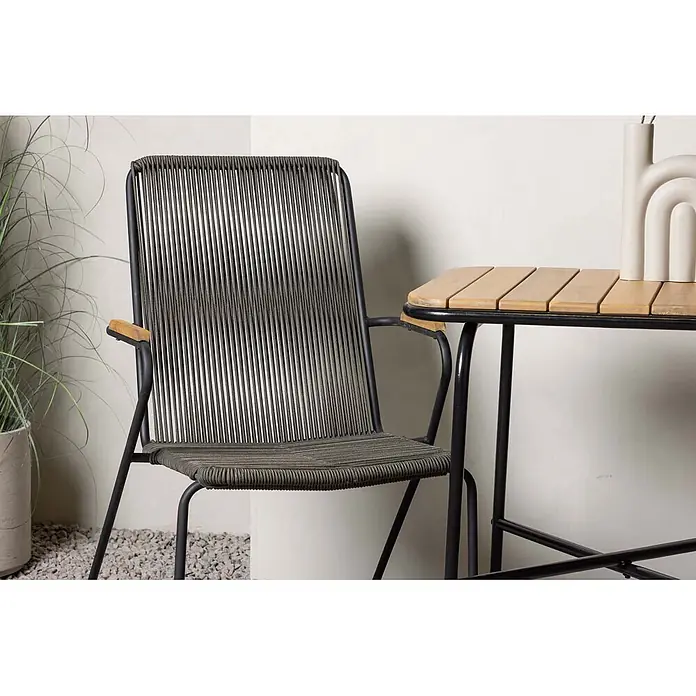 Ebuy24 Gartentisch-Set Holmbeck - Gesamtumfang: 3 -tlg., L x B x H: 88 x 70 x 74 cm, Ø x H: 88 x 74 cm, Stahl Akazie, Stapelbar - Gartenstuhl mit schwarzem Metallgestell, dunkelgrauem Seilgeflecht und Holzarmlehnen, neben einem passenden Tisch.