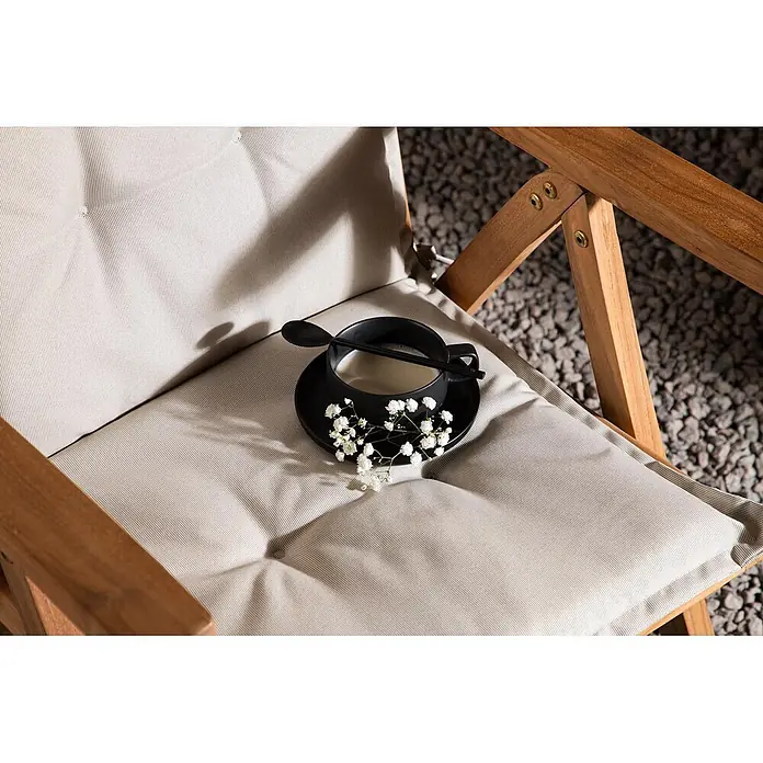 Ebuy24 Sitzauflage Cus - 1 Stk., L x B x H: 46 x 116 x 6 cm, Fasern, Schaum, Polyester., Weiß - Outdoor-Loungesessel mit hellbeigen Polstern und Holzrahmen, mit schwarzer Tasse und weißen Blumen.