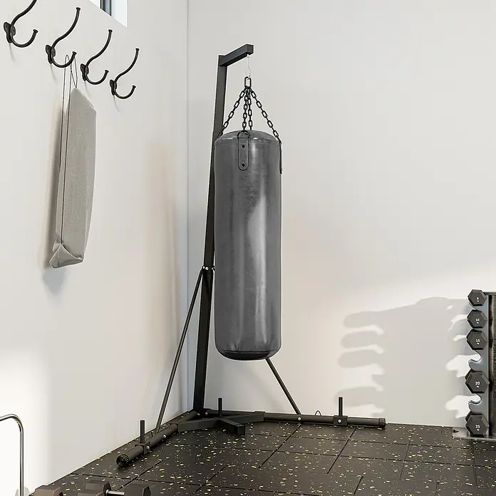 Sportnow Boxsack Ständer - Schwarz - Schwarzer Boxsack an Metallständer in einem Home-Fitnessraum mit Gummiboden, Hanteln und Wandhaken.