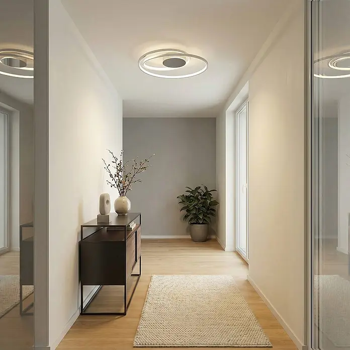 Lucande Deckenleuchte Maire - chrom / silber, chrom / silber - Moderne silber-weiße LED-Deckenleuchte mit abstraktem ovalem Design, die einen zeitgenössischen Flur beleuchtet.