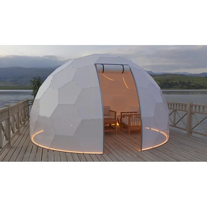 BubbleOrb Gartenkuppel - Durchmesser: 800 cm, Weiß - Weißer, facettierter Geodome auf einer Holzterrasse am See, mit warmer Innenbeleuchtung und Möbeln.