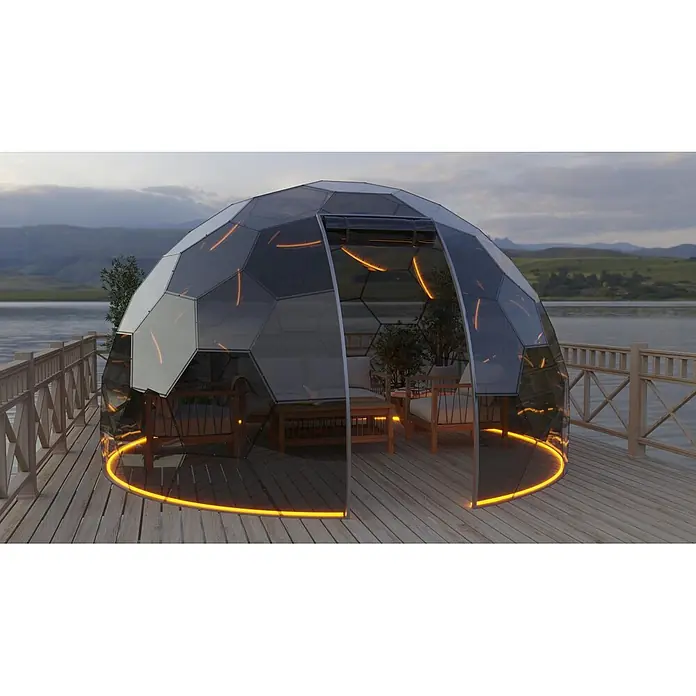 BubbleOrb Gartenkuppel - Durchmesser: 500 cm, Bronze - Transparente geodätische Gartenkuppel mit orangefarbener Innenbeleuchtung auf einem Holzdeck am See.