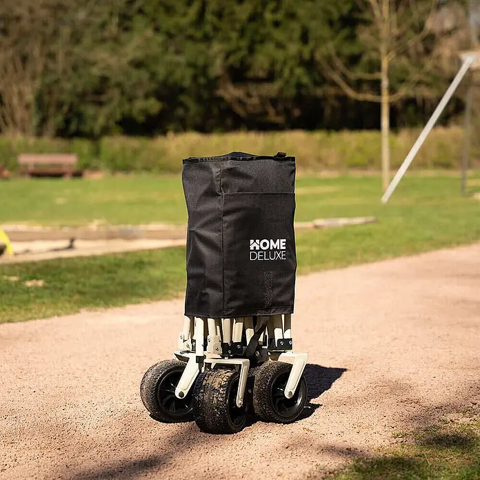Home Deluxe Bollerwagen JOLA - L x B x H: 55 x 99 x 57 cm - Schwarzer faltbarer Bollerwagen mit robusten Rädern, kompakt auf einem Kiesweg im Freien.