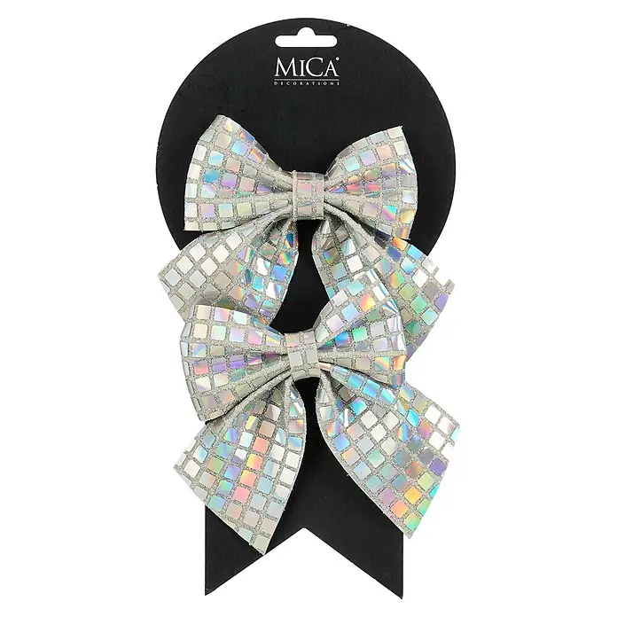Mica Decorations Deko-Schleife - Irisierend, 2 Stk. - Zwei glänzende silberne holografische Schleifen mit Glitzerdetails, befestigt an einem schwarzen MICA DECORATIONS Etikett.