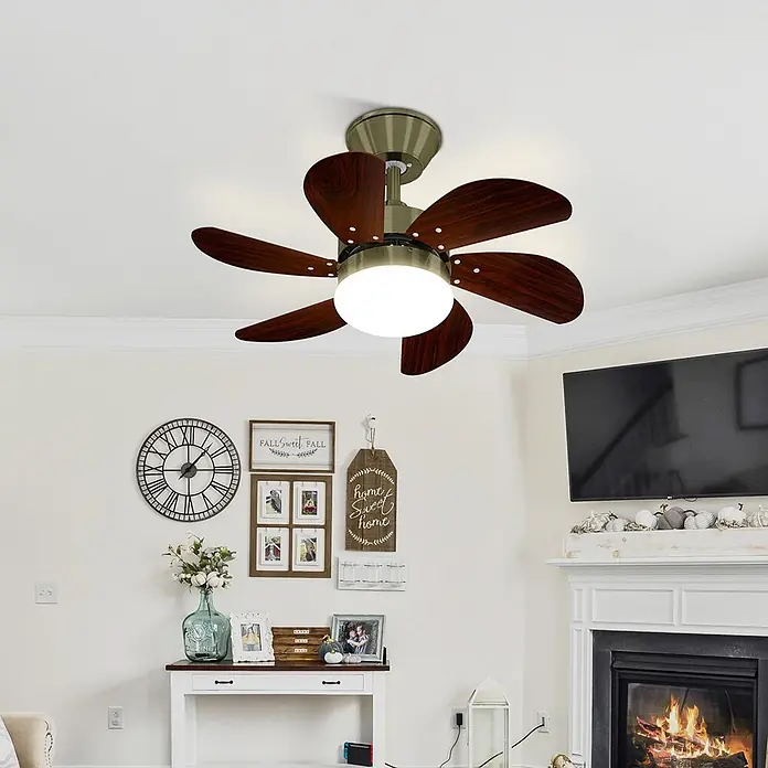 Nettlife Deckenventilator - Green, 750 mm, 57 W - Ein Deckenventilator mit dunkelbraunen Holzflügeln und messingfarbenen Beschlägen beleuchtet ein Wohnzimmer. Er hat eine helle weiße Kuppelleuchte.