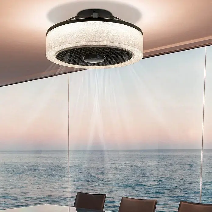 Nettlife Deckenventilator - Black, 400 mm, 40 W - Runder schwarzer Deckenventilator mit mattiertem Lichtring, an der Decke installiert, bläst Luft in einem Raum mit Meerblick.