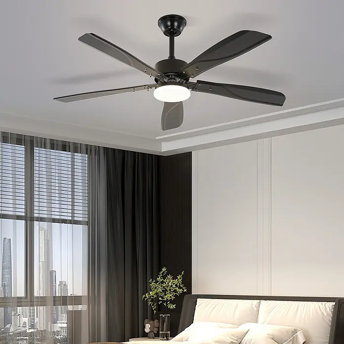 Nettlife Deckenventilator - Black, 1.250 mm, 53 W - Schwarzer Deckenventilator mit fünf Flügeln und zentralem weißen Licht, über einem modernen Bett.