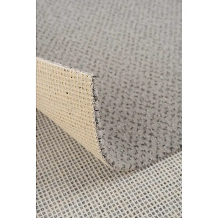 Bricoflor Teppichboden Meterware 6x4m, Velours gemustert, hell-grau - Velours, 100 % Polyamid (PA), hell-grau - Hellgrauer Teppich mit strukturierter Oberfläche, zeigt seine beige, gerasterte Anti-Rutsch-Unterseite.