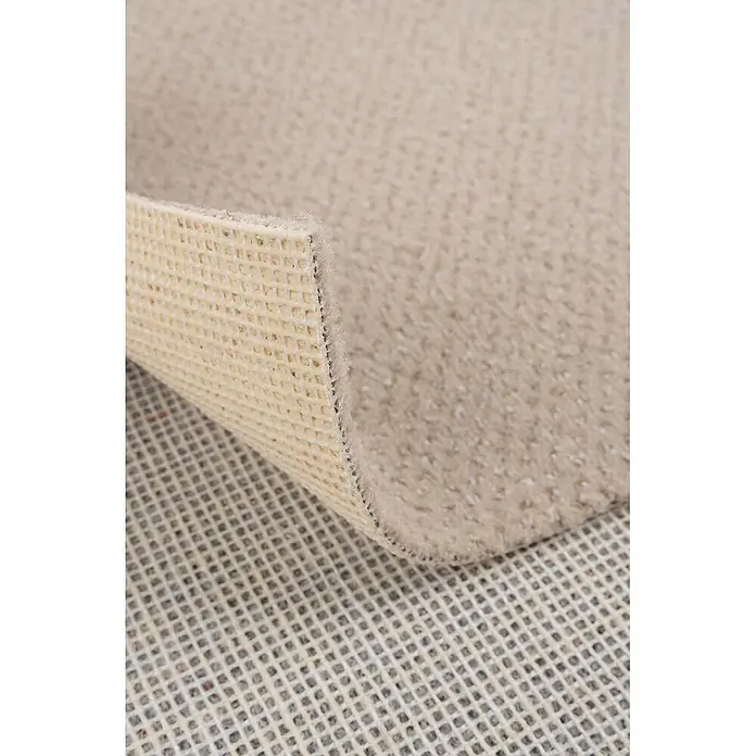 Bricoflor Teppichboden Meterware 8,5x4m, Velours gemustert, hell-beige - Velours, 100 % Polyamid (PA), hell-beige - Heller beigefarbener Teppich mit sichtbarer strukturierter Rückseite, teilweise angehoben über einer Gitter-Unterlage.
