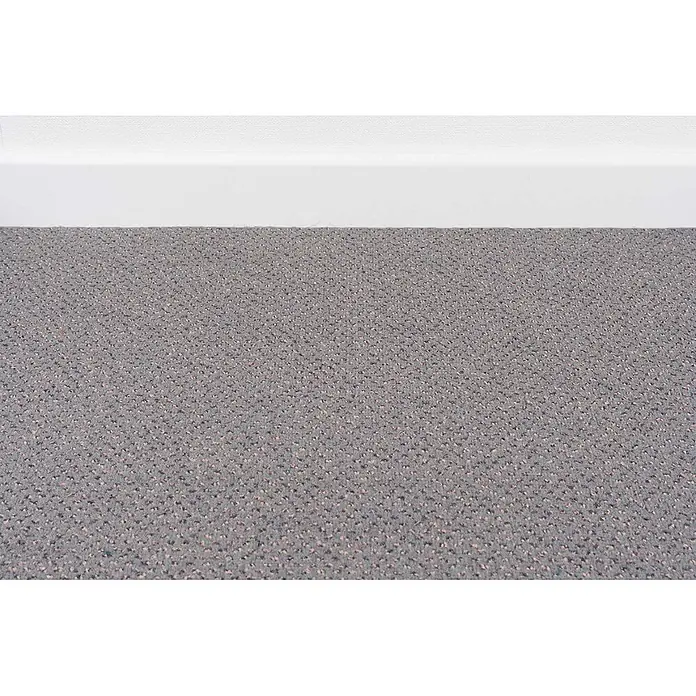 Bricoflor Teppichboden Meterware 2,5x4m, Velours gemustert, grau - Velours, 100 % Polyamid (PA), grau - Nahaufnahme eines grauen, strukturierten Teppichs mit gesprenkeltem Design, verlegt an einer weißen Fußleiste.