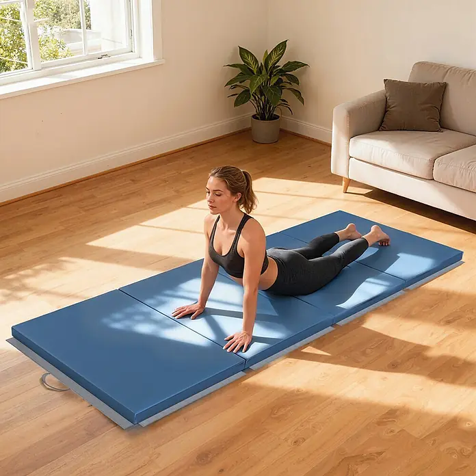 Homcom Universalmatte Gymnastikmatte - 240 x 120 cm, Hellblau, Kunststoff - Eine Frau macht eine Kobra-Pose auf einer großen blauen faltbaren Gymnastikmatte in einem sonnigen Raum.