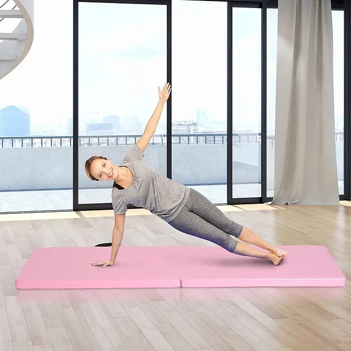 Homcom Universalmatte Gymnastikmatte - 180 x 60 cm, Rosa, Sonstiges - Eine Frau trainiert auf einer hellrosafarbenen, faltbaren Fitnessmatte in einem hellen Raum.