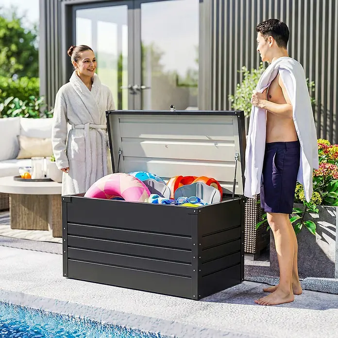 Outsunny Garten-Aufbewahrungsbox - Grau, Stahl - Geöffnete dunkelgraue Aufbewahrungsbox am Pool, gefüllt mit bunten Schwimmaccessoires.