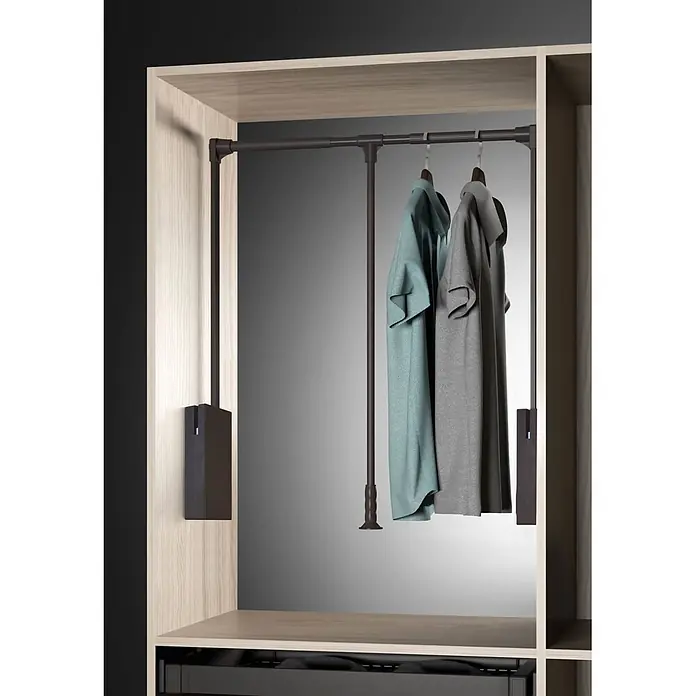 M.Pascual Colgador abatible - Ajuste de la anchura: 830 mm - 1.150 mm, Capacidad de carga: 12 kg - Sistema elevador de armario de metal oscuro en un mueble de madera clara, con dos camisas colgando. Facilita el acceso a la ropa alta.