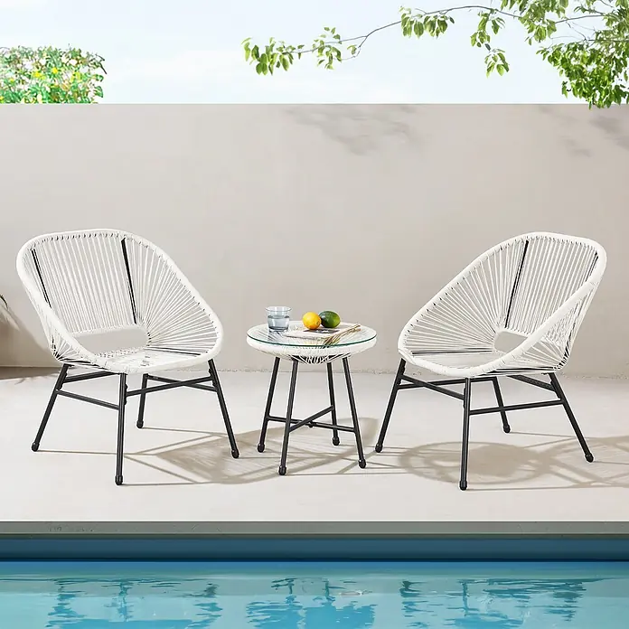 SVITA Balkonmöbel-Set TULUM - 3 -tlg., Polyrattan, pulverbeschichteter Stahl - Zwei weiße Seilstühle und ein runder Glastisch mit schwarzen Metallrahmen stehen auf einer Terrasse neben einem Pool.