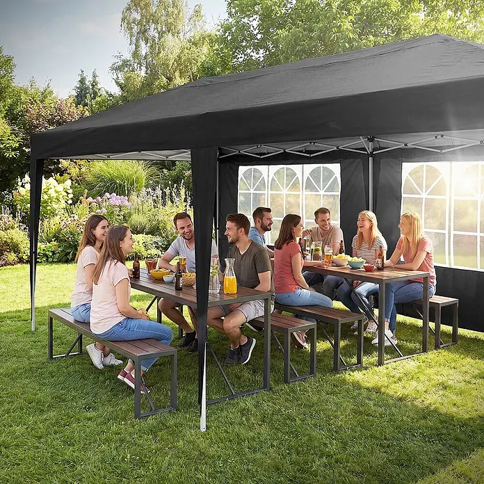 ECD Germany Faltpavillon - B x T: 600 x 600 cm, Farbe Dach: Schwarz - Ein schwarzer Pavillon mit Seitenwänden und Fenstern, der Schatten spendet, während Leute in einem sonnigen Garten essen und trinken.