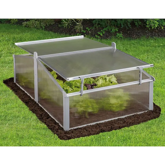 Juwel Vivero superpuesto Easy-Fix 120/80 - L x An x Al: 120 x 80 x 40 cm - Mini invernadero transparente con marco plateado, tapas parcialmente abiertas mostrando lechuga verde dentro, sobre tierra.