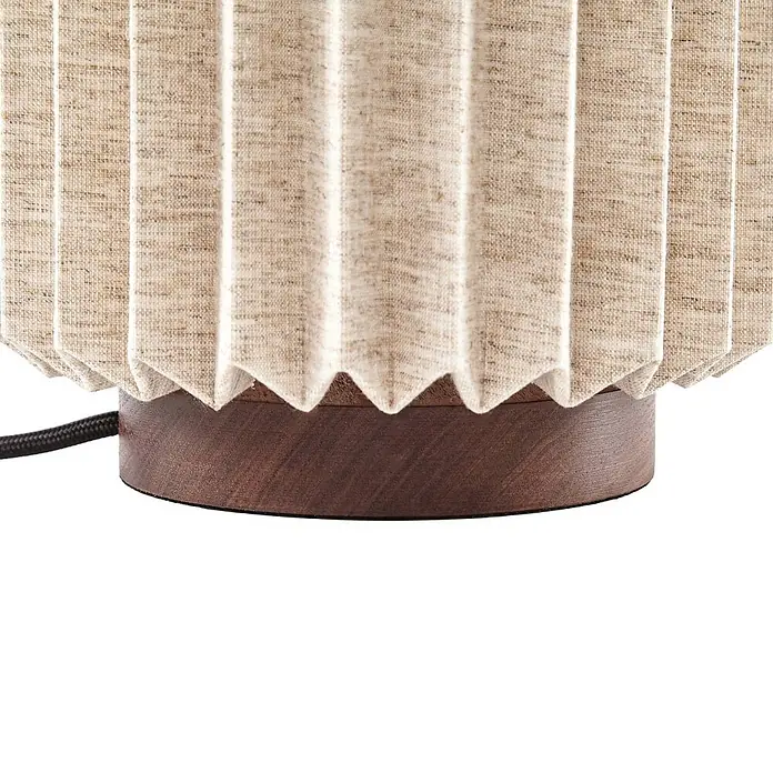 Lindby Tischleuchte Maveo - Holz dunkel, alu / grau / zink, E27 - Beiger plissierter Stofflampenschirm auf dunklem Holzsockel mit schwarzem Netzkabel.