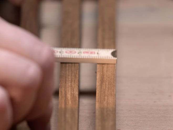 Der Abstand der Holzlatten wird gemessen