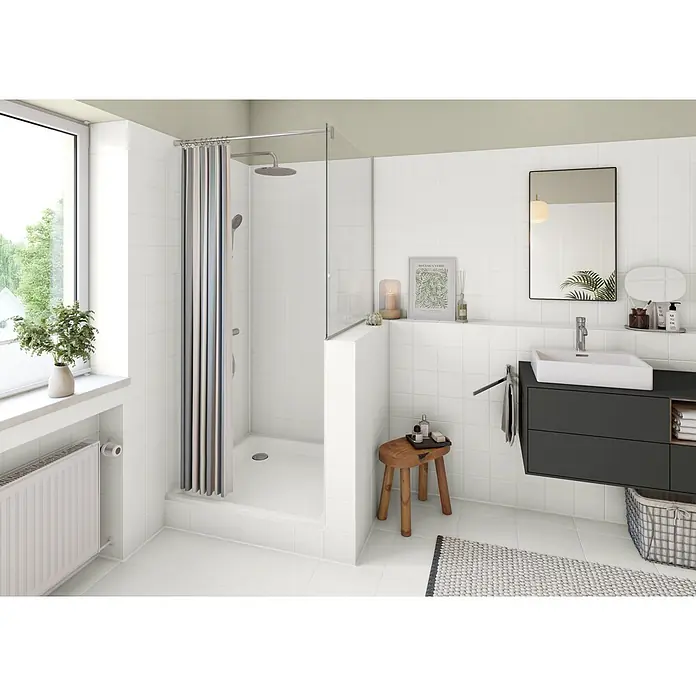 Alpina Weißlack Bad & Küche 3 in 1 Fliesenlack (Weiß) - Weiß, Seidenglänzend, 500 l, Lösemittelbasiert - Ein helles, modernes Badezimmer mit einer begehbaren Dusche mit gestreiftem Vorhang, einem dunklen Waschtisch mit weißem Aufsatzwaschbecken und einem großen Fenster.