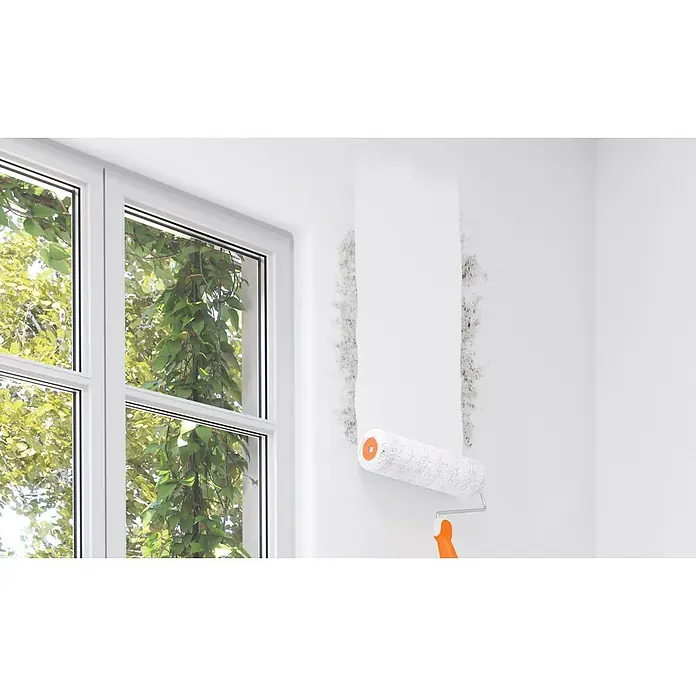 Alpina Wandfarbe Schimmel- & Fleckenblocker - Weiß, Seidenglänzend, 750 l - Farbroller bedeckt schwarzen Schimmel an einer weißen Wand neben einem Fenster mit grünen Bäumen draußen.