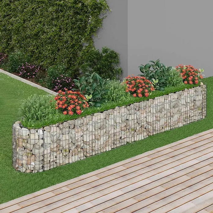 Furnicato Gabionen-Hochbeet - 330 x 50 x 50 cm, Metall - Gekrümmtes Gabionen-Hochbeet, gefüllt mit Steinen und Pflanzen, in einem Garten mit Rasen und Holzdeck.